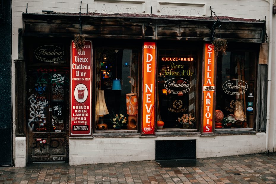 Street photography in Brussels on a rainy day – old pub façade with red beer signs
