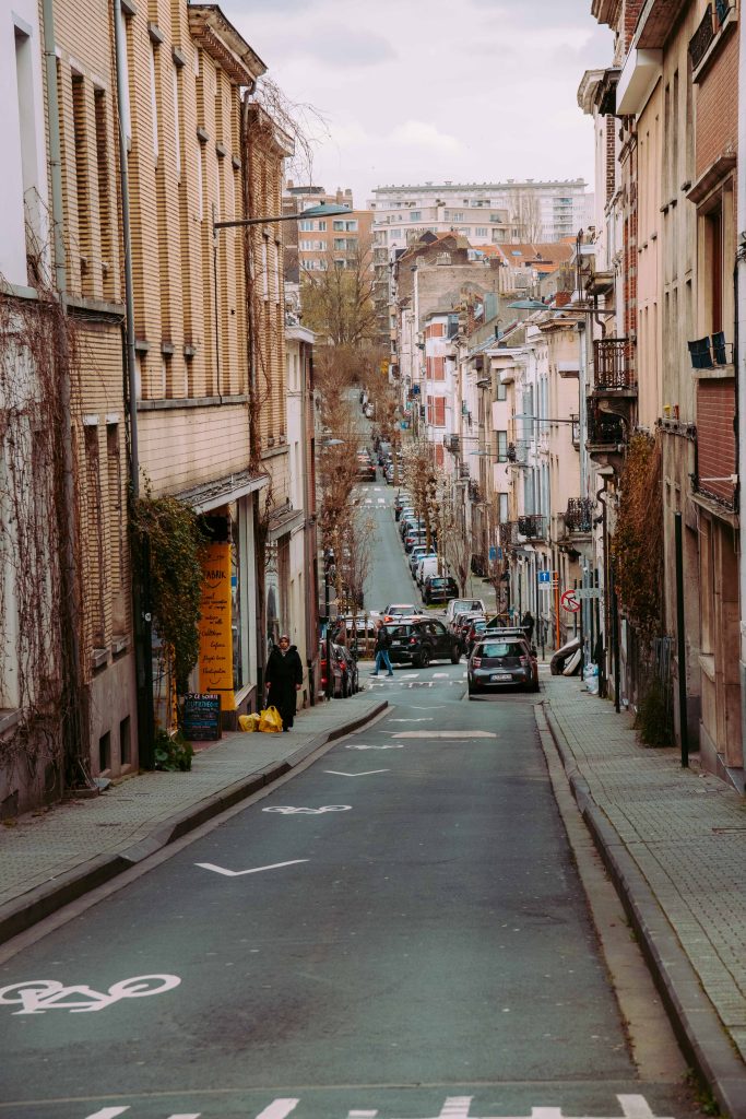 Narrow sloping street in Brussels with dense buildings and urban depth