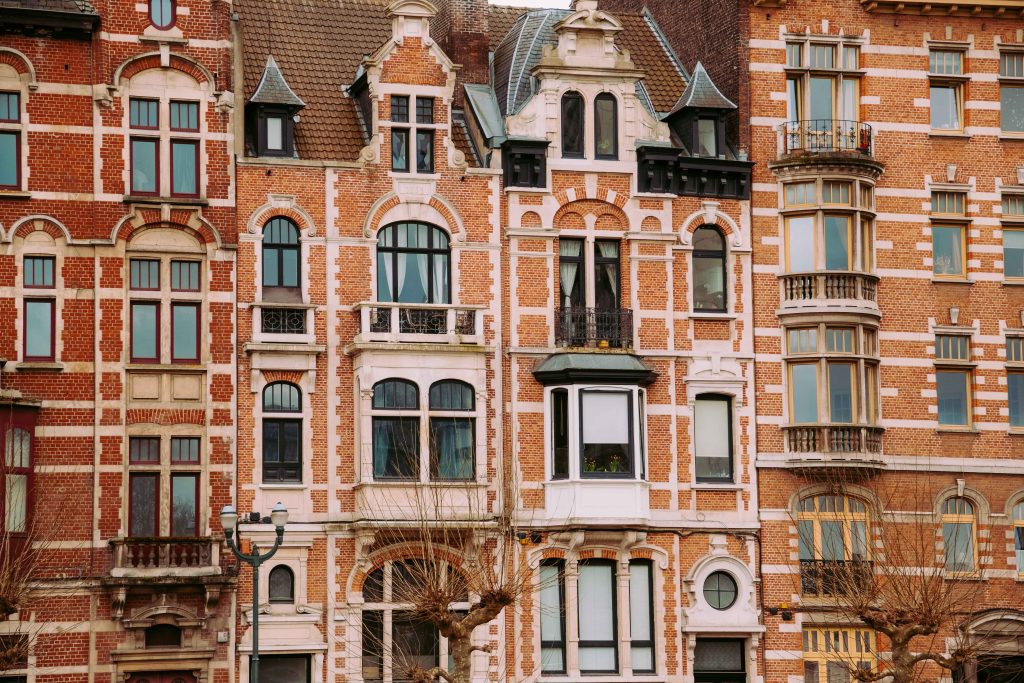 Ornate red brick residential buildings in Brussels with detailed windows and decorative facades