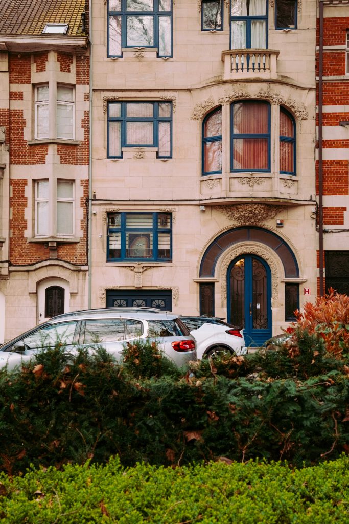 Traditional Brussels townhouse facade with blue window frames and decorative stone elements